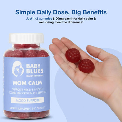 Close-up of hands holding two raspberry-shaped gummies from Baby Blues Mom Calm bottle.